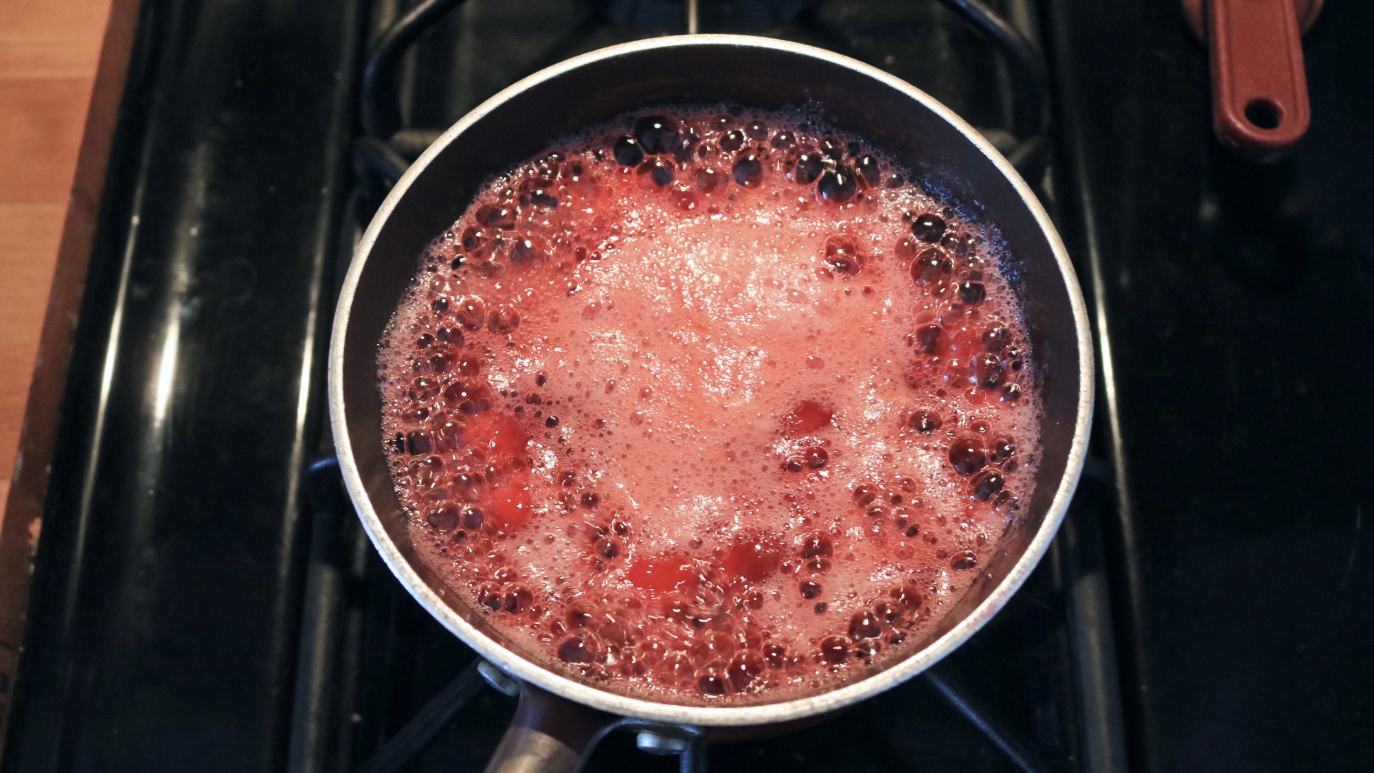 Cranberries boiling in a pot.