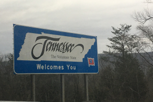 Close-up of a welcome to Tennessee sign on the side of the road.