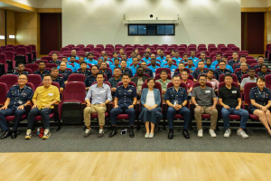 Singapore Police ambassadors sat in seats in a small auditorium-like room. Singapore Police announces new migrant worker ambassadors, working to address gambling risks